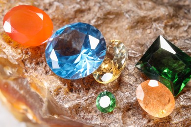 Photo of Beautiful shiny colorful gemstones on rock, closeup