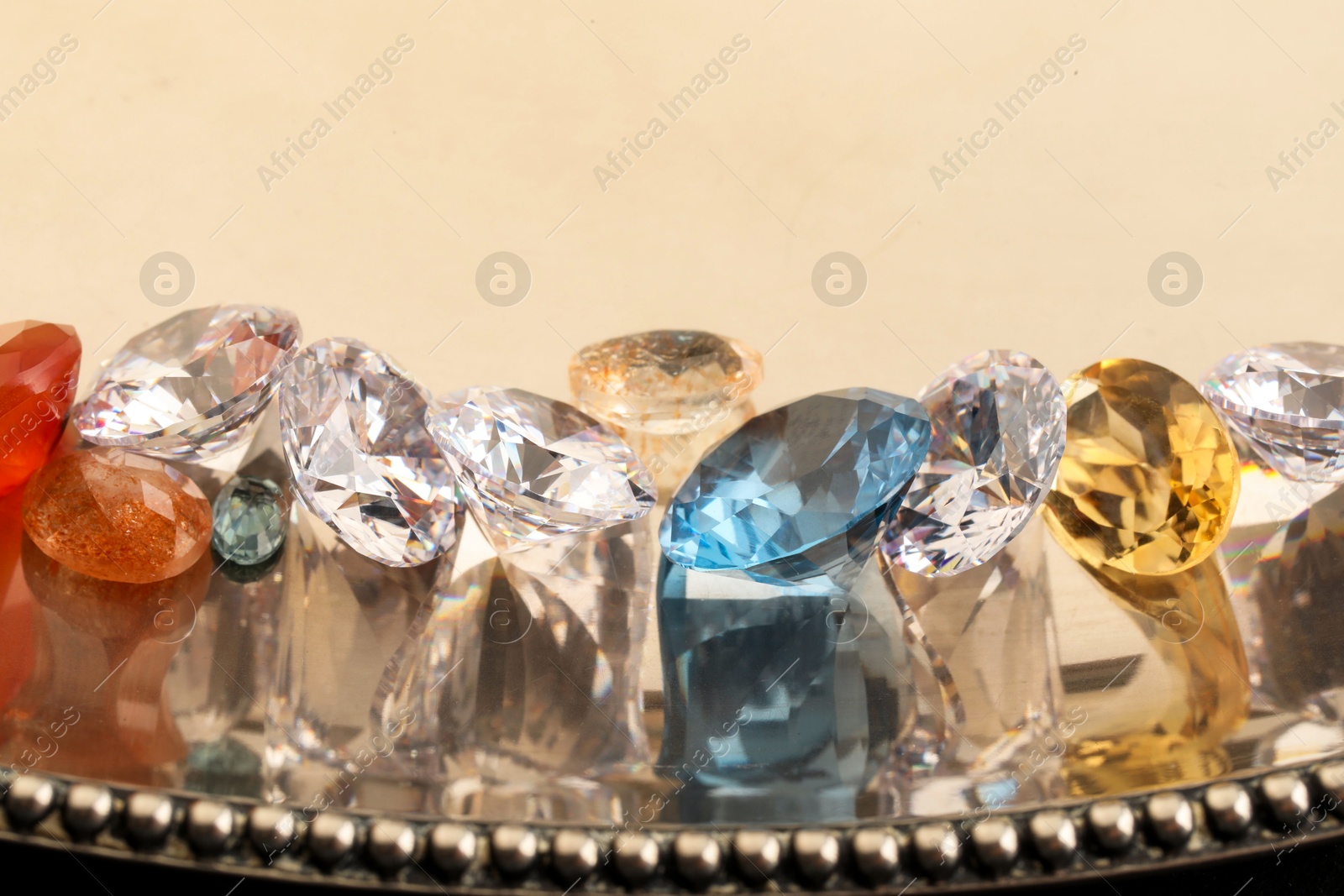 Photo of Beautiful shiny colorful gemstones on light background, closeup