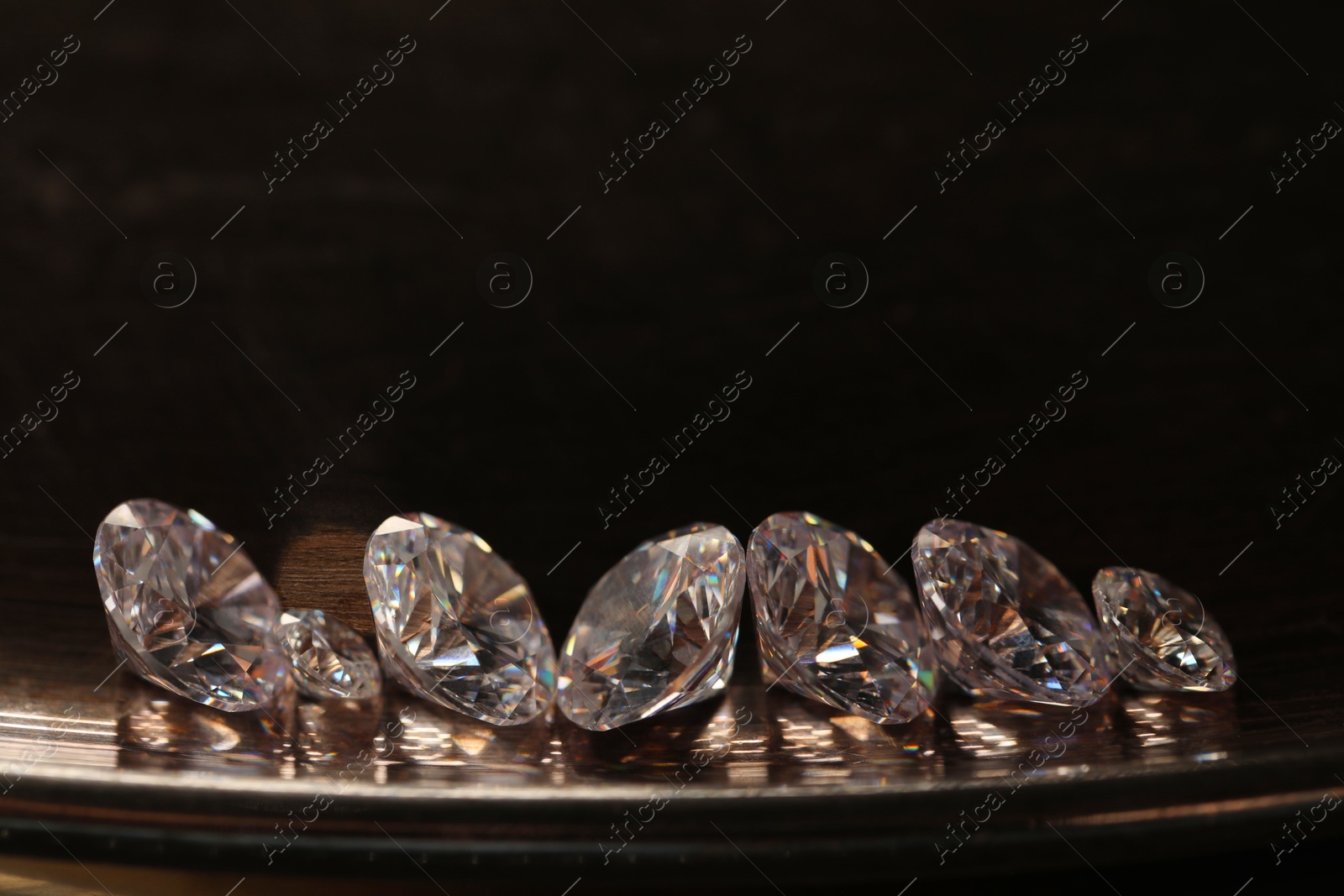 Photo of Beautiful shiny gemstones on metal tray. Space for text