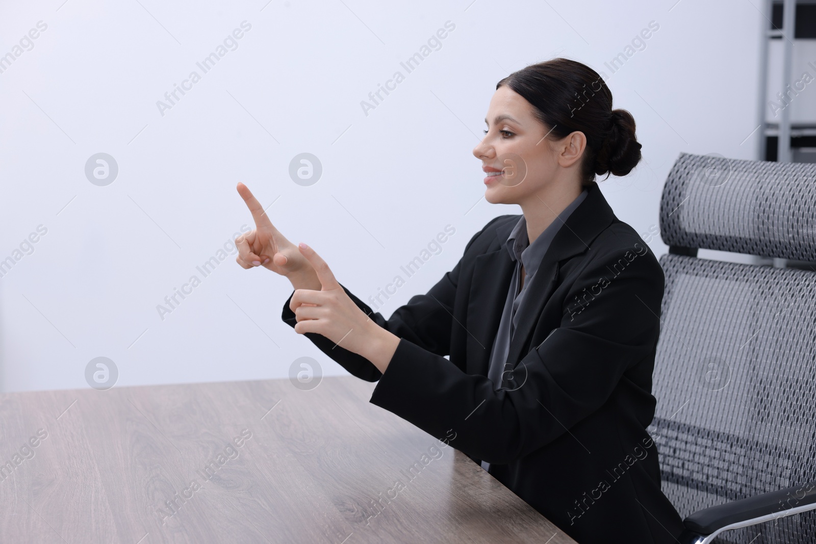 Photo of Beautiful woman pointing at something in office, space for text