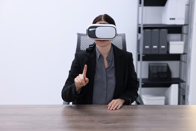 Photo of Woman using virtual reality headset in office