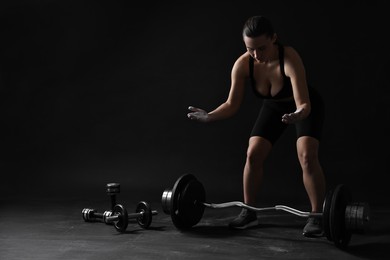 Photo of Woman with talcum powder on her hands preparing to training against black background. Space for text