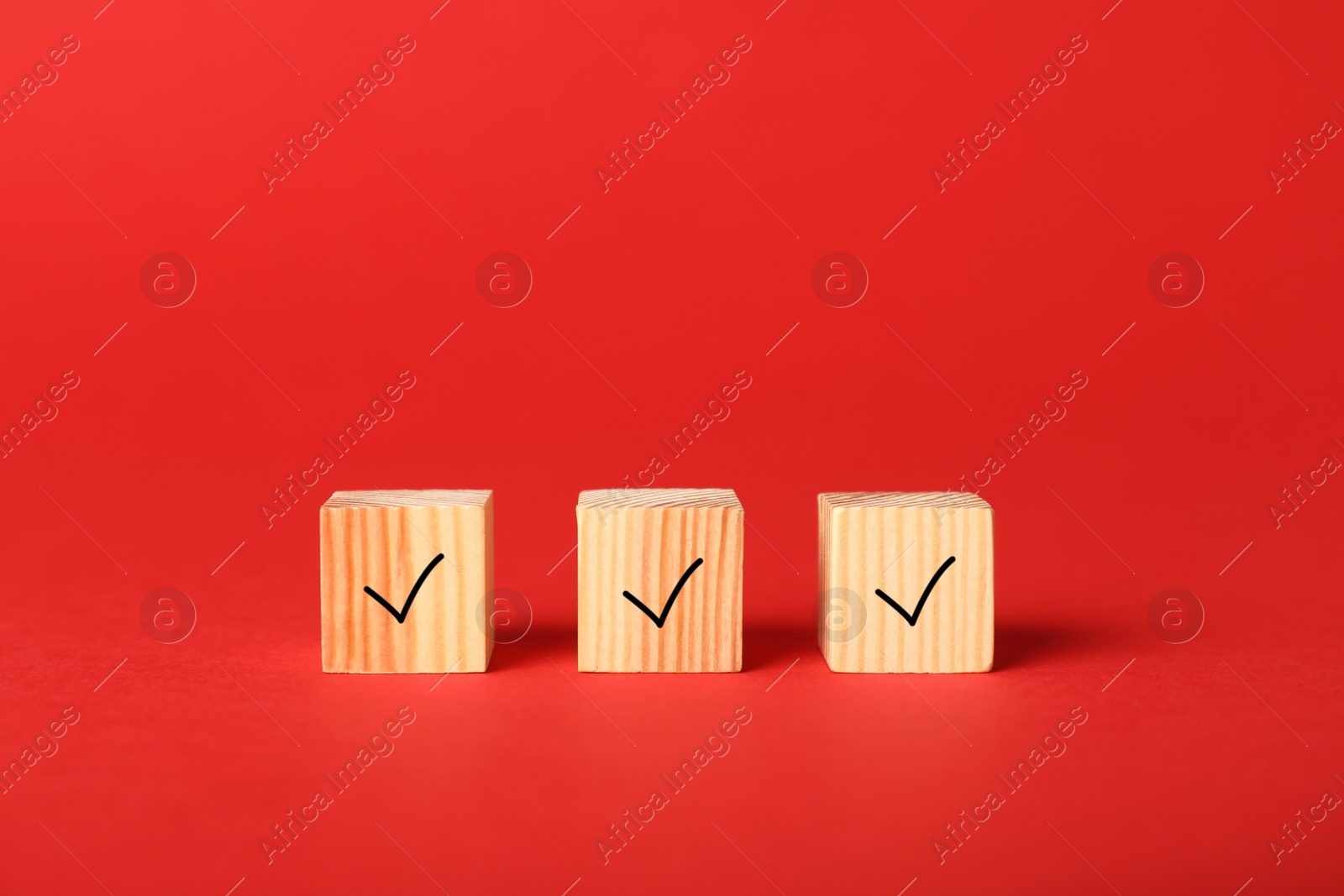 Photo of Wooden cubes with check marks on red background