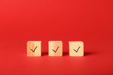 Photo of Wooden cubes with check marks on red background