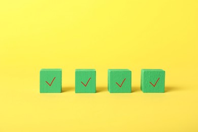 Photo of Green cubes with check marks on yellow background