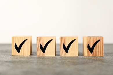 Photo of Wooden cubes with check marks on grey table