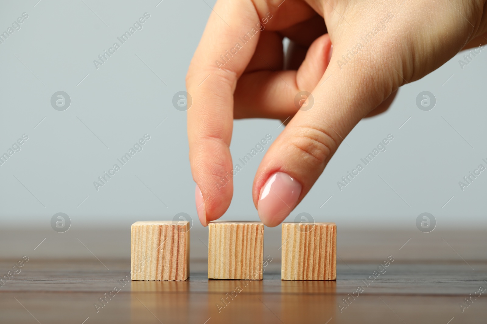 Photo of Woman with wooden cubes at table, closeup