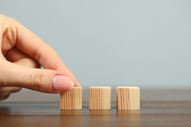 Photo of Woman with wooden cubes at table, closeup