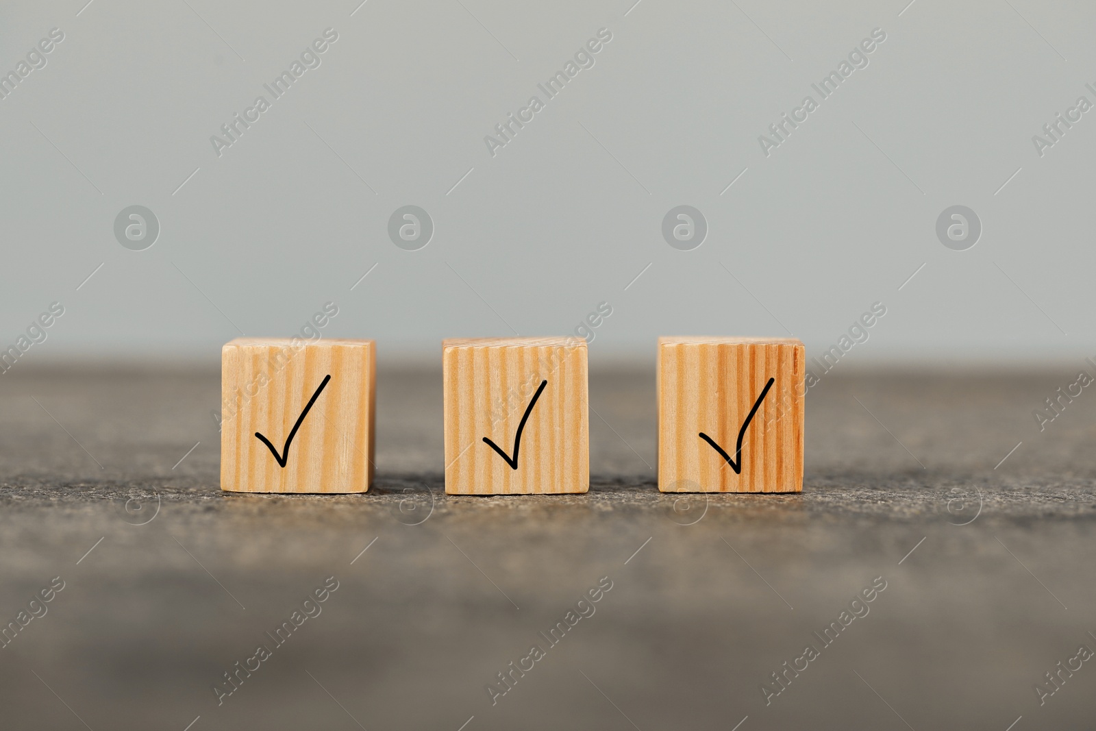 Photo of Wooden cubes with check marks on grey table