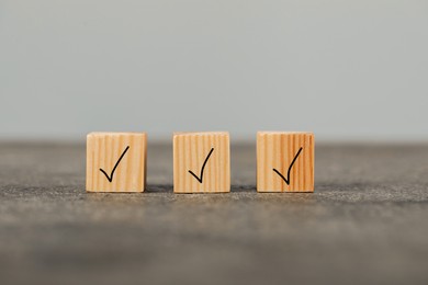 Photo of Wooden cubes with check marks on grey table