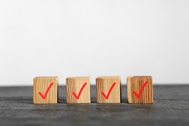 Photo of Wooden cubes with check marks on grey table