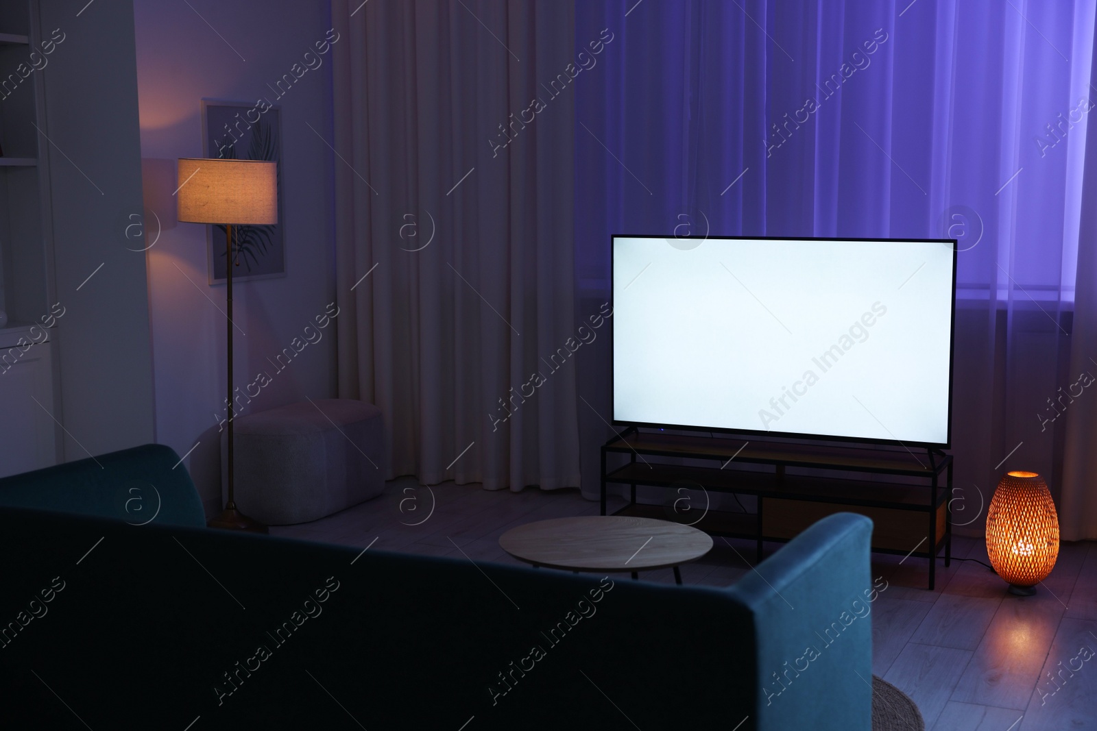 Photo of Big modern tv in stylish living room at evening