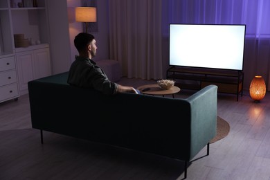 Man watching tv at home in evening