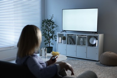 Woman watching tv on couch at home