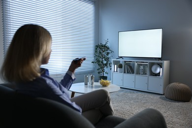 Woman watching tv on couch at home