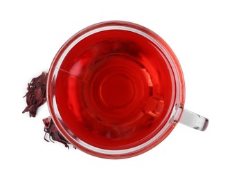 Photo of Delicious hibiscus tea in glass cup and dry roselle sepals isolated on white, top view