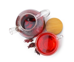 Photo of Delicious hibiscus tea in glass cup, teapot and dry roselle sepals isolated on white, top view