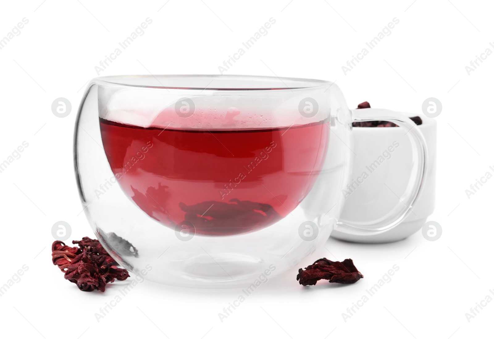 Photo of Delicious hibiscus tea in glass cup and dry roselle sepals isolated on white