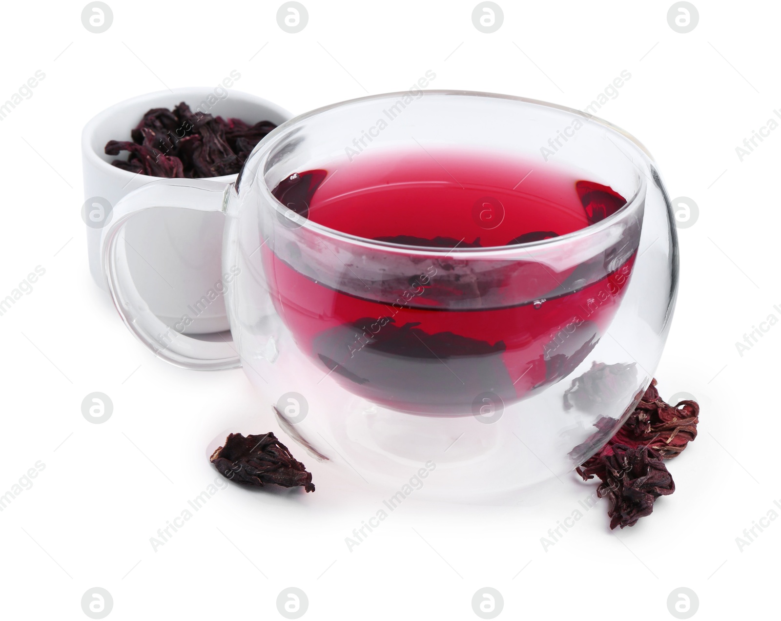 Photo of Delicious hibiscus tea in glass cup and dry roselle sepals isolated on white