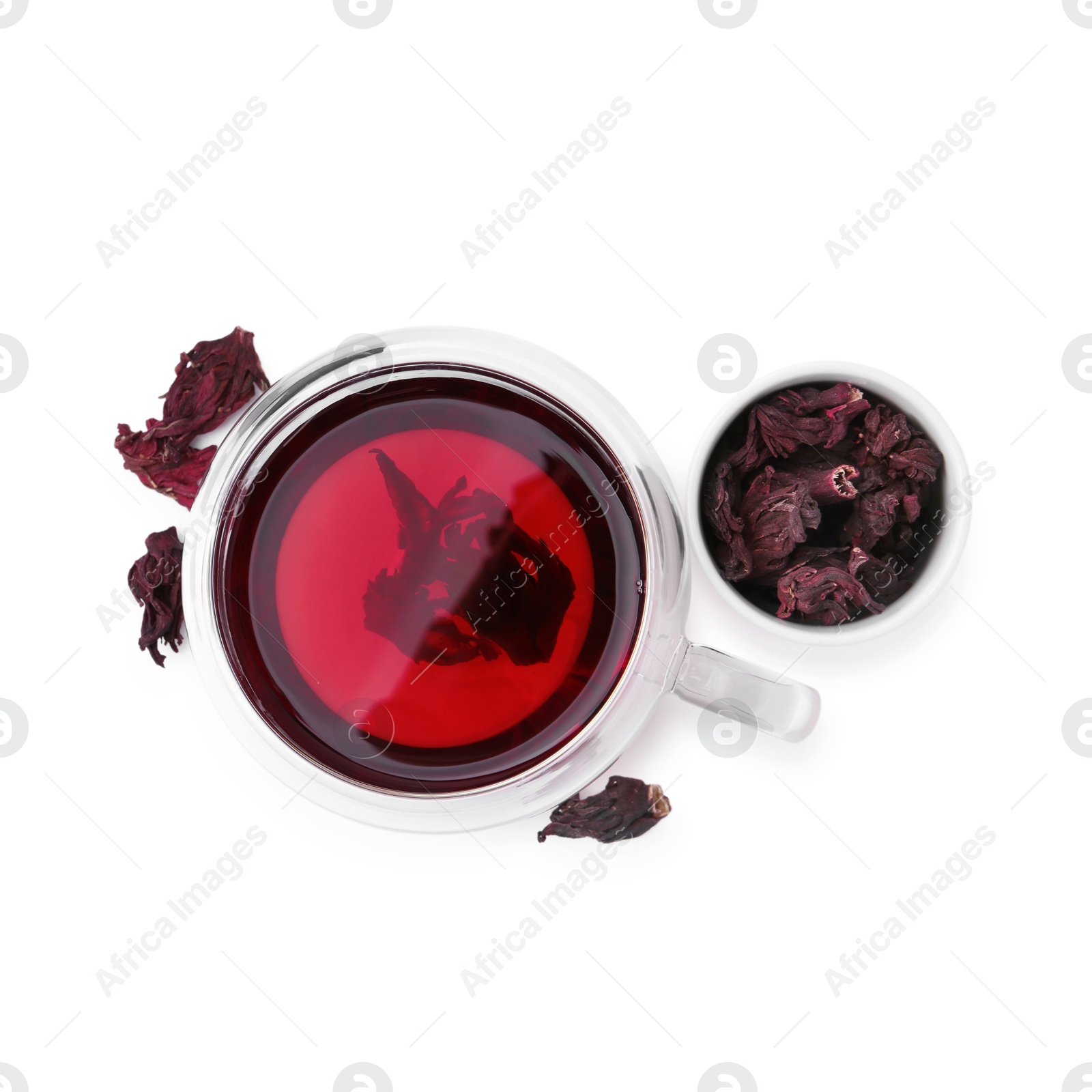 Photo of Delicious hibiscus tea in glass cup and dry roselle sepals isolated on white, top view