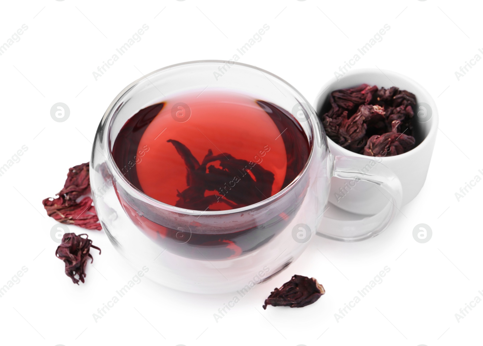 Photo of Delicious hibiscus tea in glass cup and dry roselle sepals isolated on white