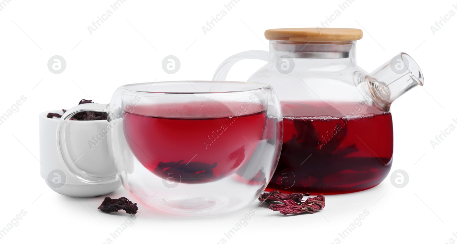 Photo of Delicious hibiscus tea in glass cup, teapot and dry roselle sepals isolated on white