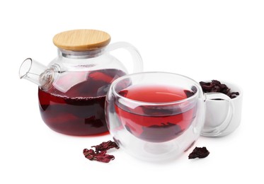 Photo of Delicious hibiscus tea in glass cup, teapot and dry roselle sepals isolated on white