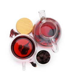 Photo of Delicious hibiscus tea in glass cup, teapot and dry roselle sepals isolated on white, top view