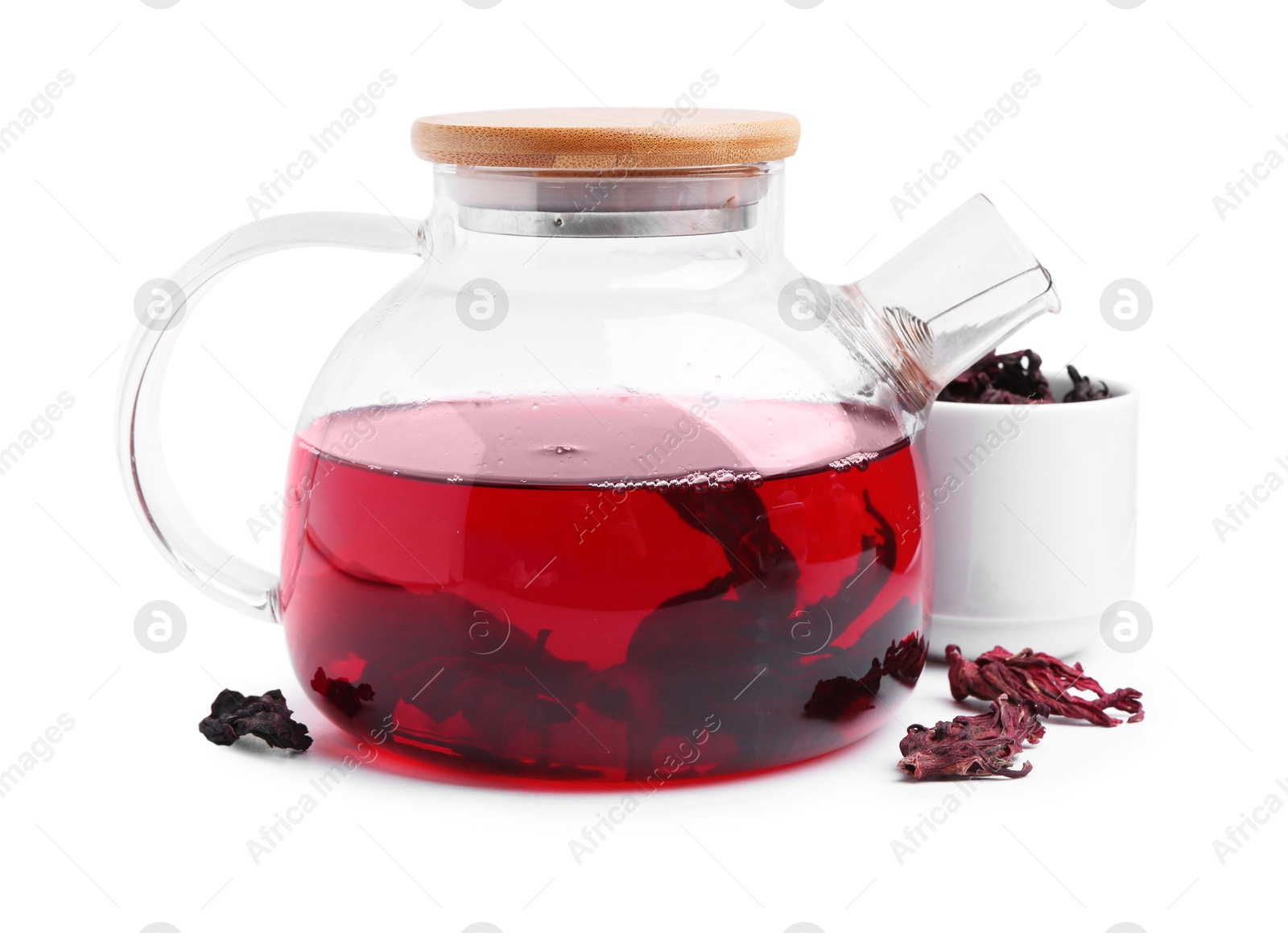 Photo of Delicious hibiscus tea in glass teapot and dry roselle sepals isolated on white