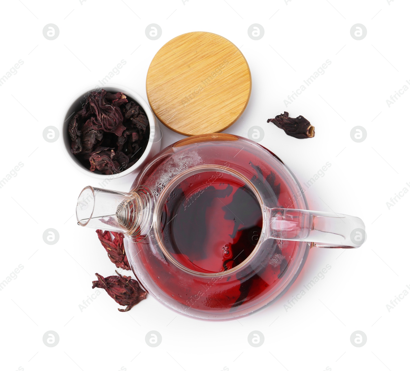 Photo of Delicious hibiscus tea in glass teapot and dry roselle sepals isolated on white, top view