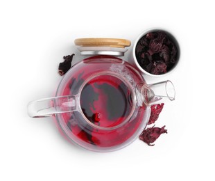 Photo of Delicious hibiscus tea in glass teapot and dry roselle sepals isolated on white, top view