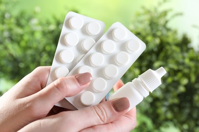 Photo of Allergy treatment. Woman with medical drops and pills on blurred background, closeup