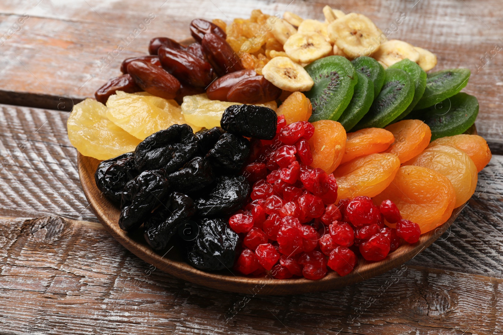 Photo of Different dried fruits on wooden table, closeup