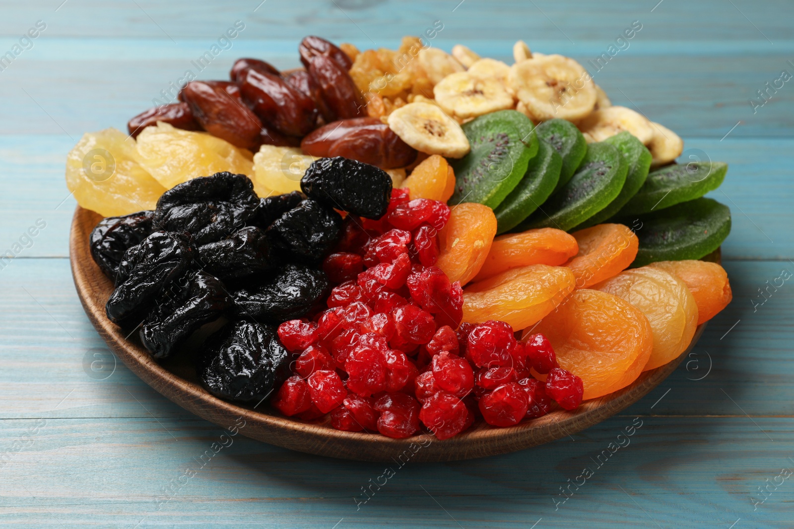 Photo of Different dried fruits on blue wooden table, closeup