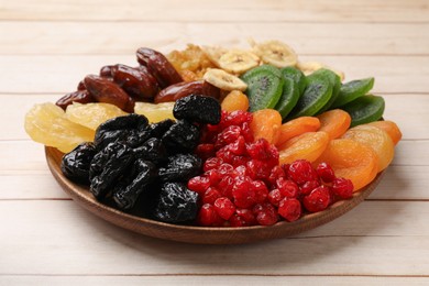 Photo of Different dried fruits on white wooden table, closeup