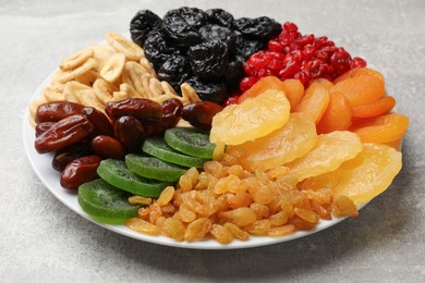 Photo of Mix of different dried fruits on grey table, closeup