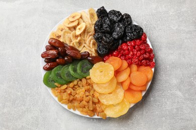 Photo of Mix of different dried fruits on grey table, top view