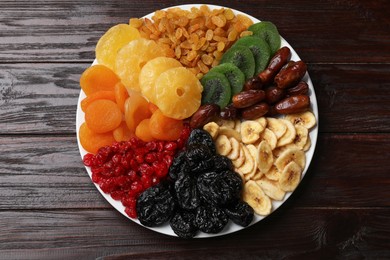 Photo of Mix of different dried fruits on wooden table, top view