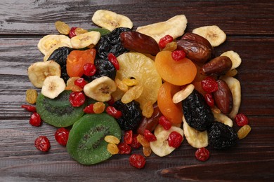 Photo of Mix of different dried fruits on wooden table, top view