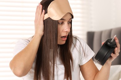 Photo of Overslept woman with alarm clock in bed at home