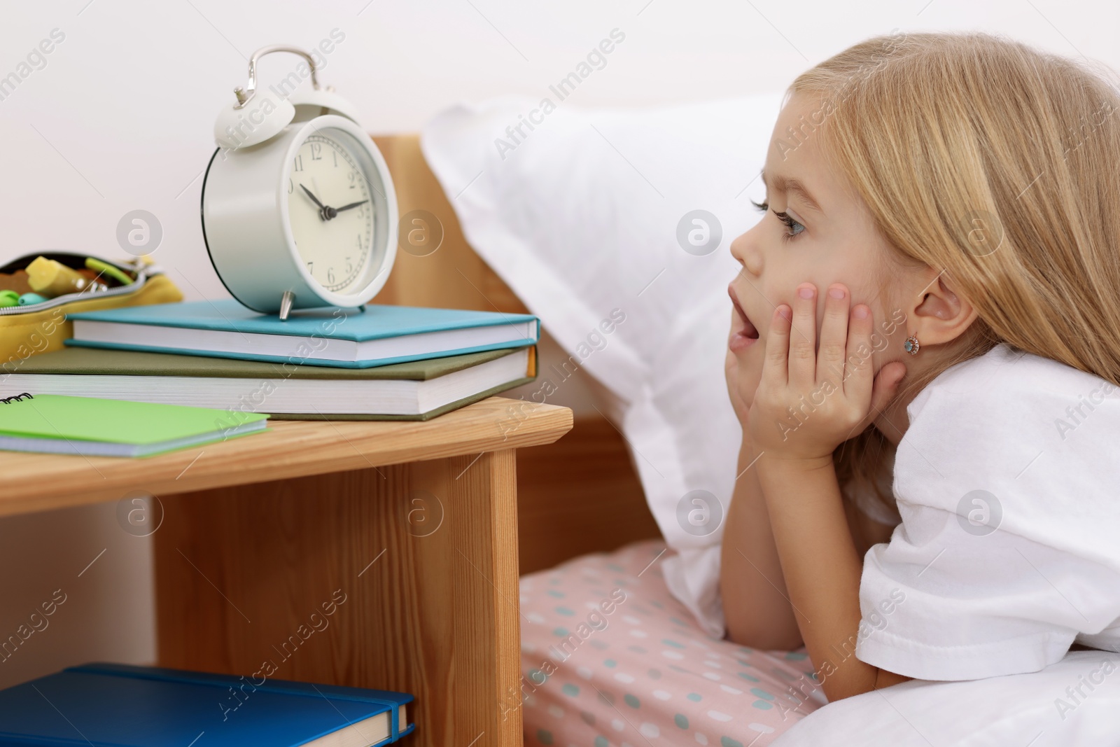 Photo of Overslept girl with alarm clock in bed at home