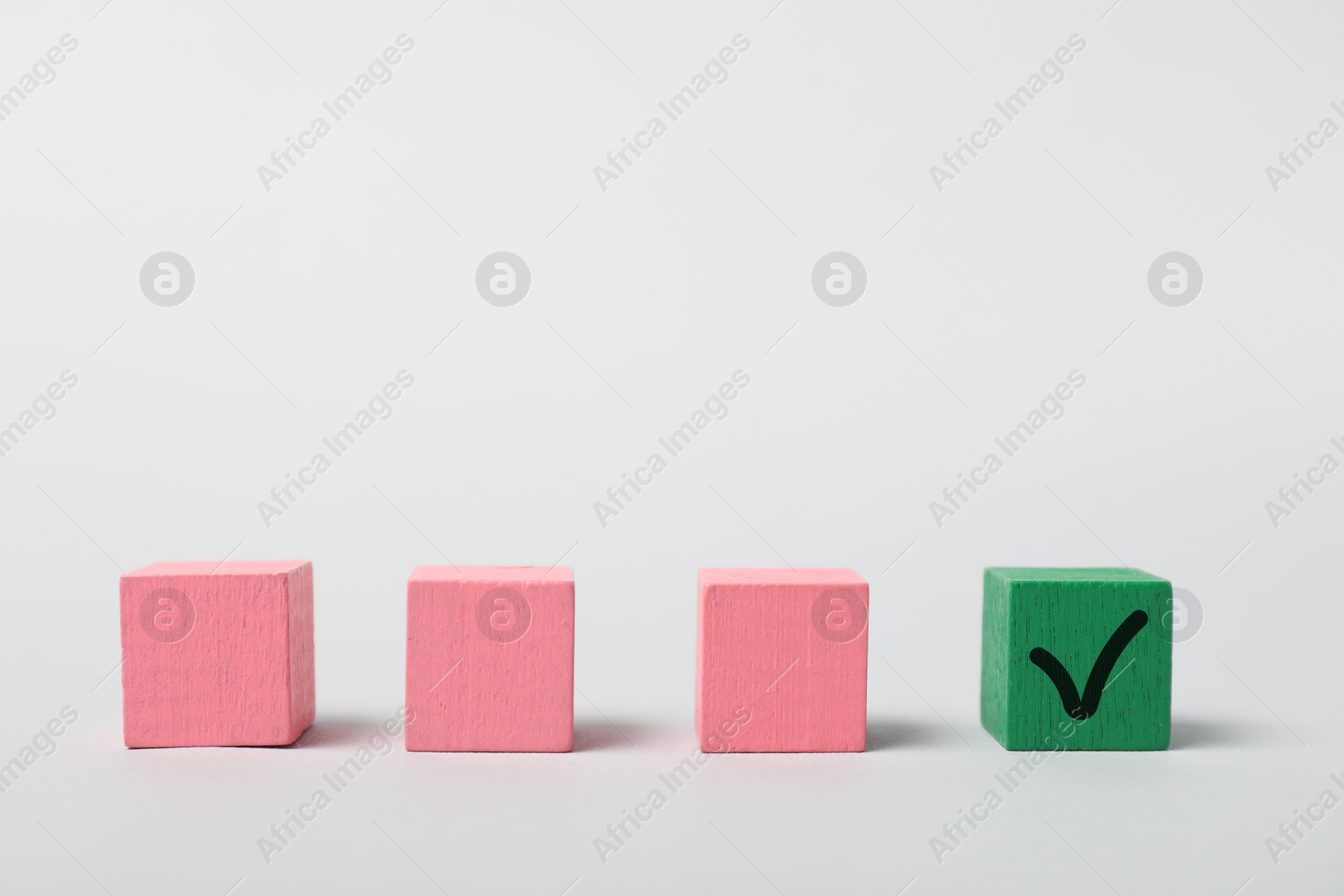 Photo of One green cube with check mark among others on white background