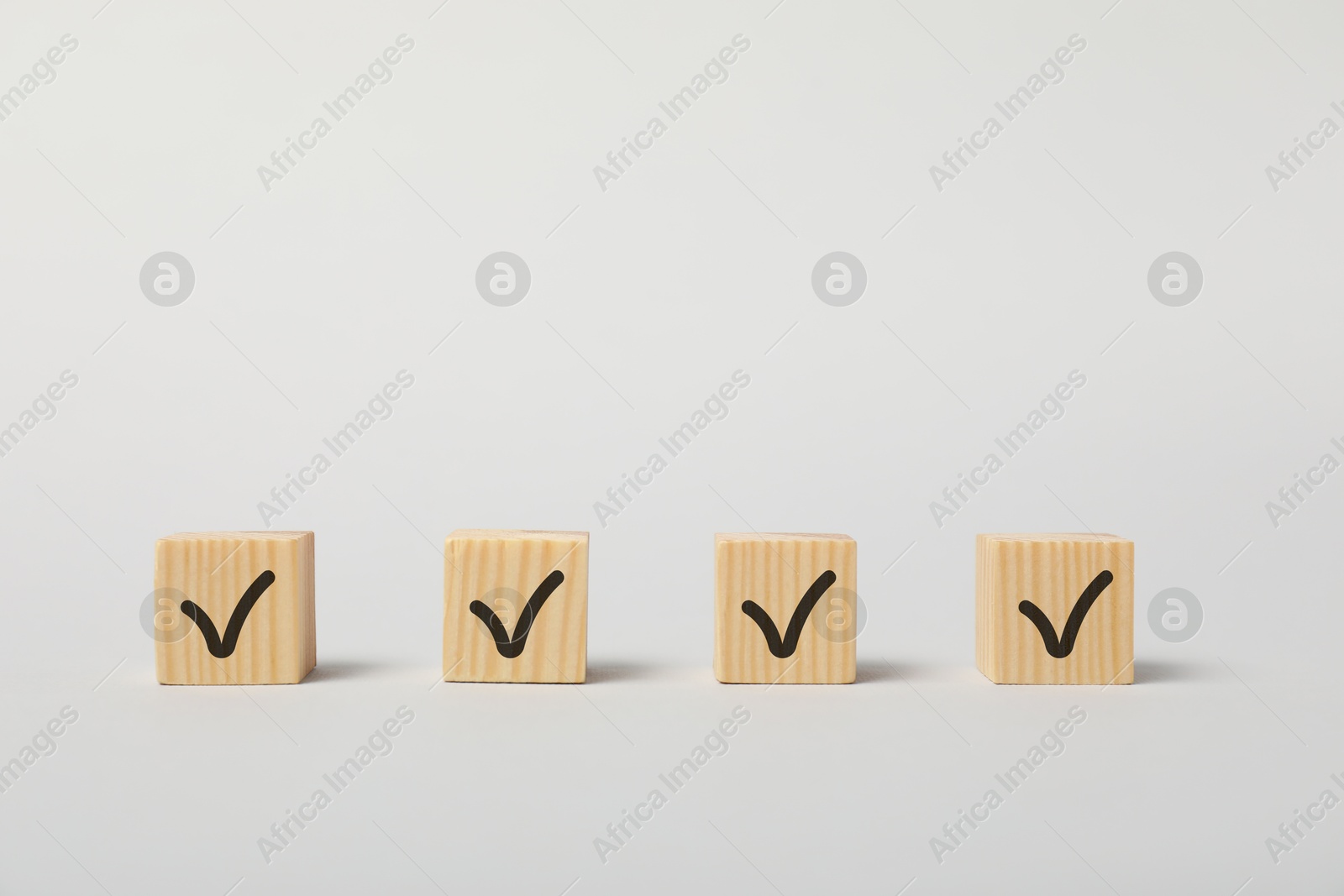 Photo of Wooden cubes with check marks on white background