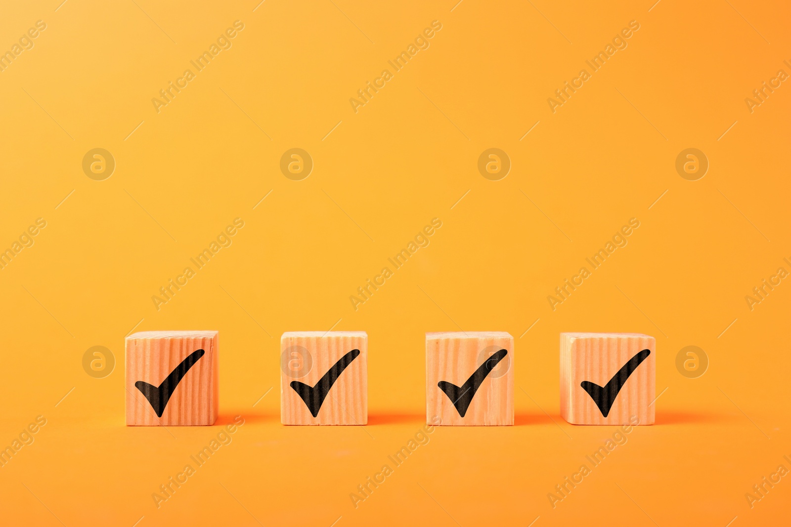 Photo of Wooden cubes with check marks on orange background