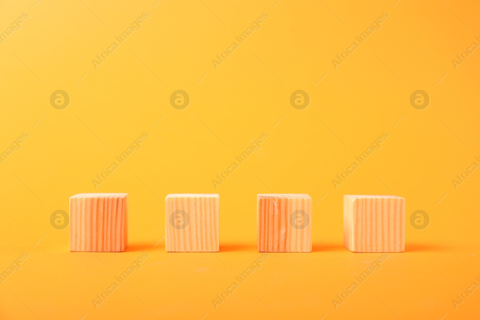 Photo of Many wooden cubes on orange background, space for text