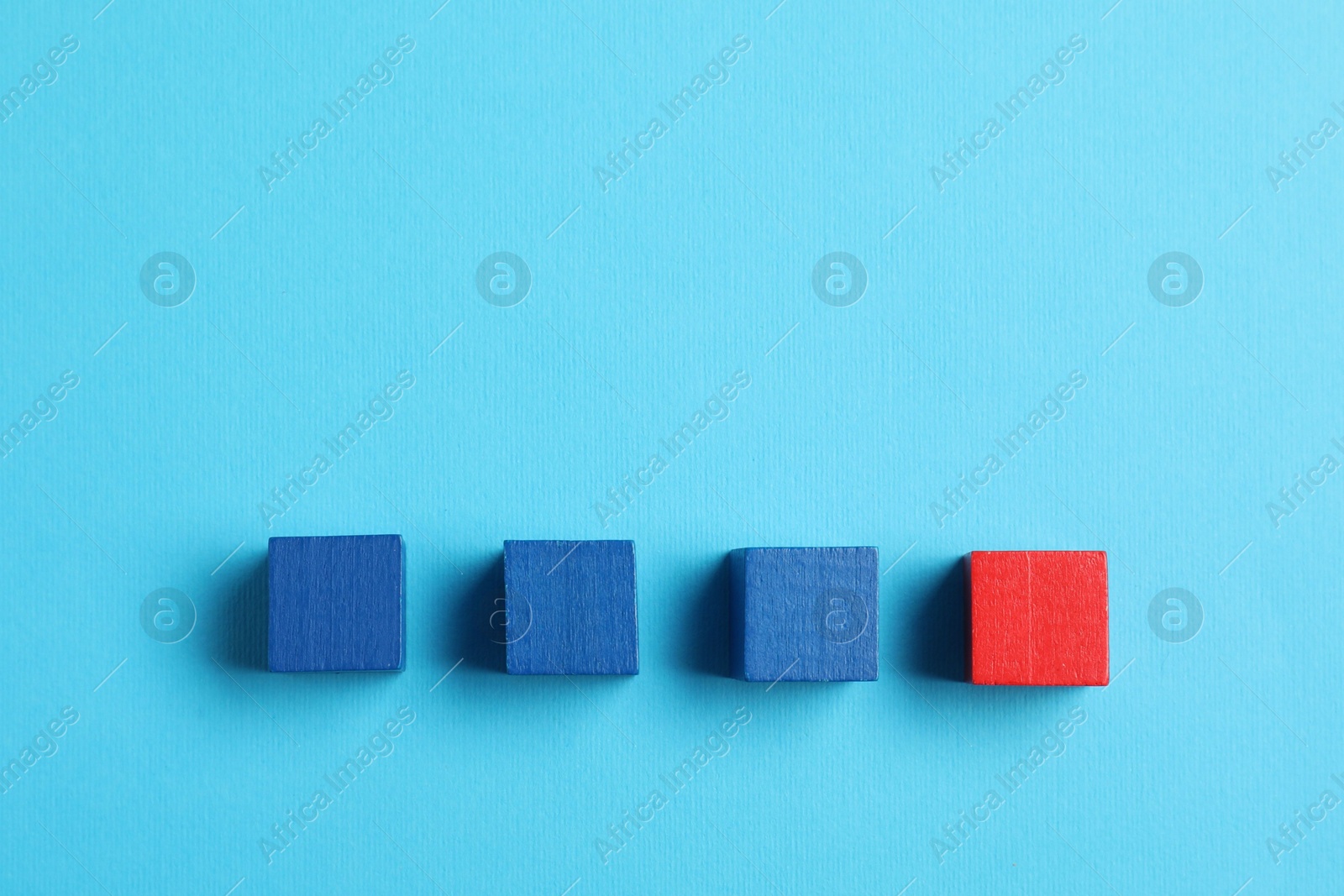 Photo of Many colorful wooden cubes on light blue background, flat lay. Space for text