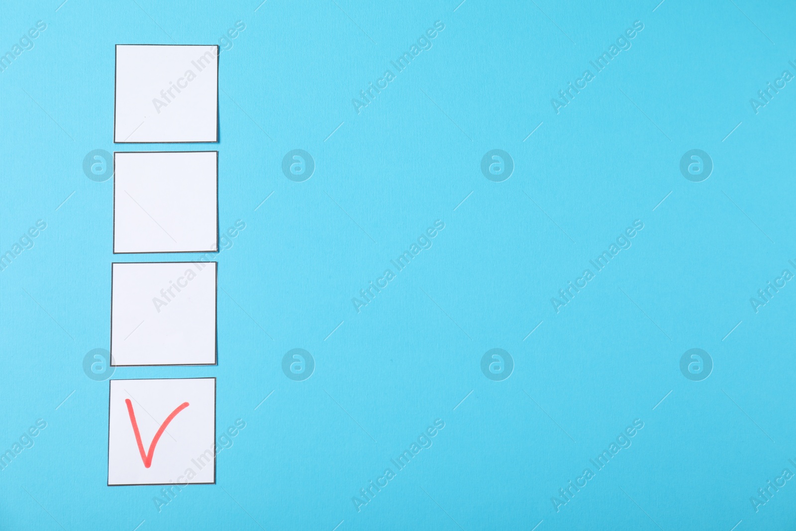 Photo of One checkbox with tick mark among others on light blue background, flat lay. Space for text