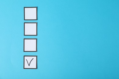 Photo of One checkbox with tick mark among others on light blue background, flat lay. Space for text