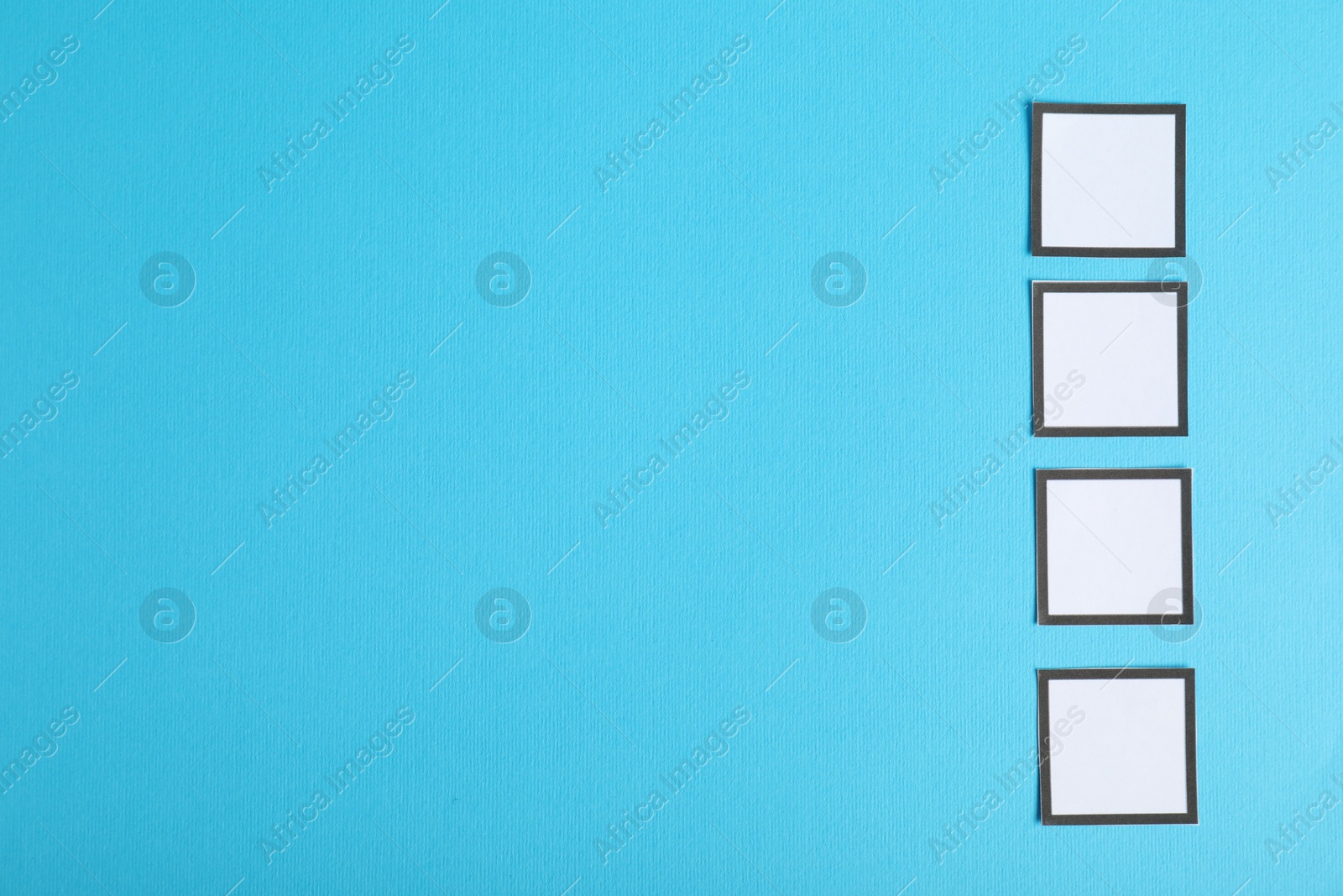 Photo of Empty checkboxes on light blue background, flat lay. Space for text