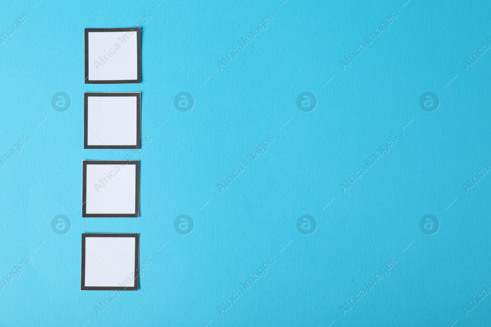 Photo of Empty checkboxes on light blue background, flat lay. Space for text